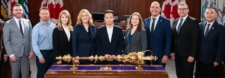 Vanpoover city officials looking smug and posing next to a big golden stick